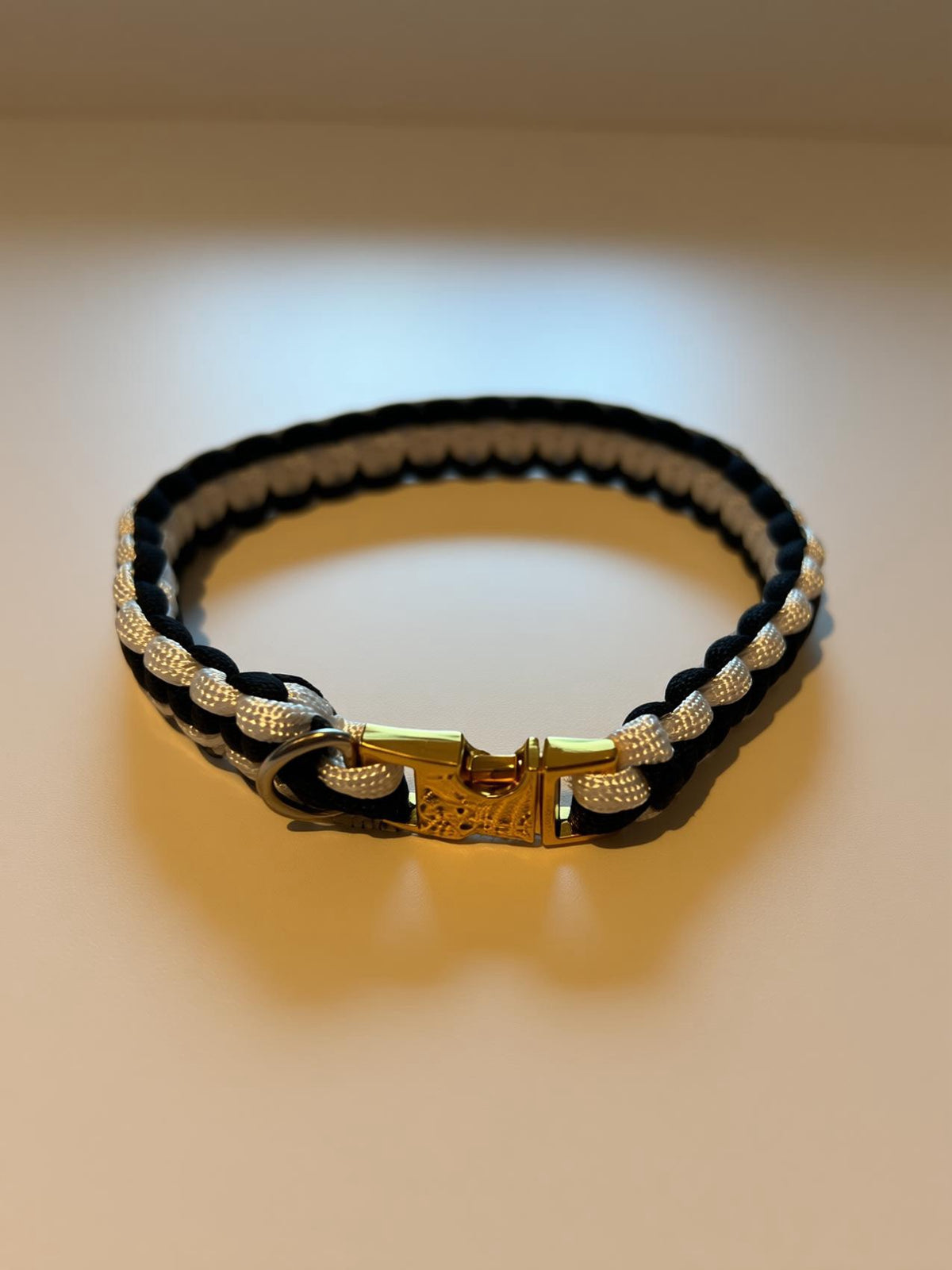  “Black-and-white striped woven paracord dog collar shown against a light background.”